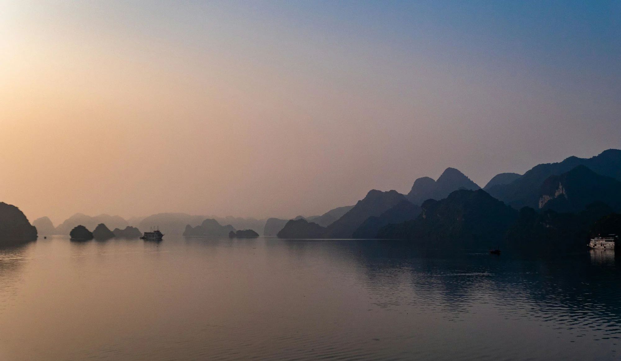 silhouette of mountains near calm body of water