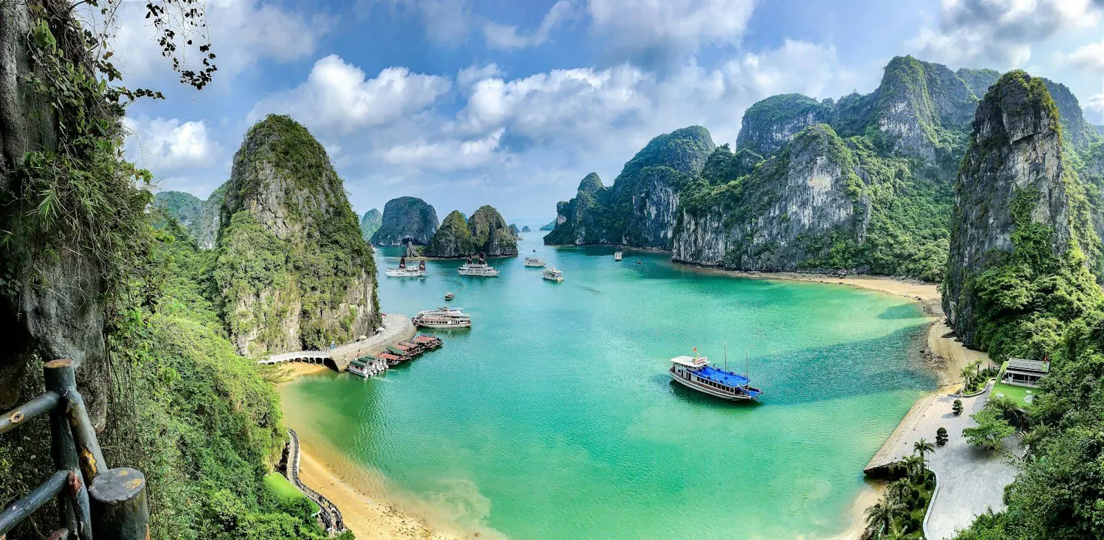 Boats on the turquoise water of Ha Long Bay surrounded by limestone karst islands