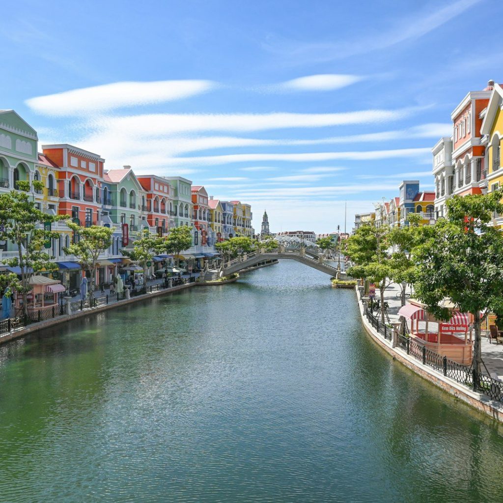 Colorful buildings line a canal with a bridge