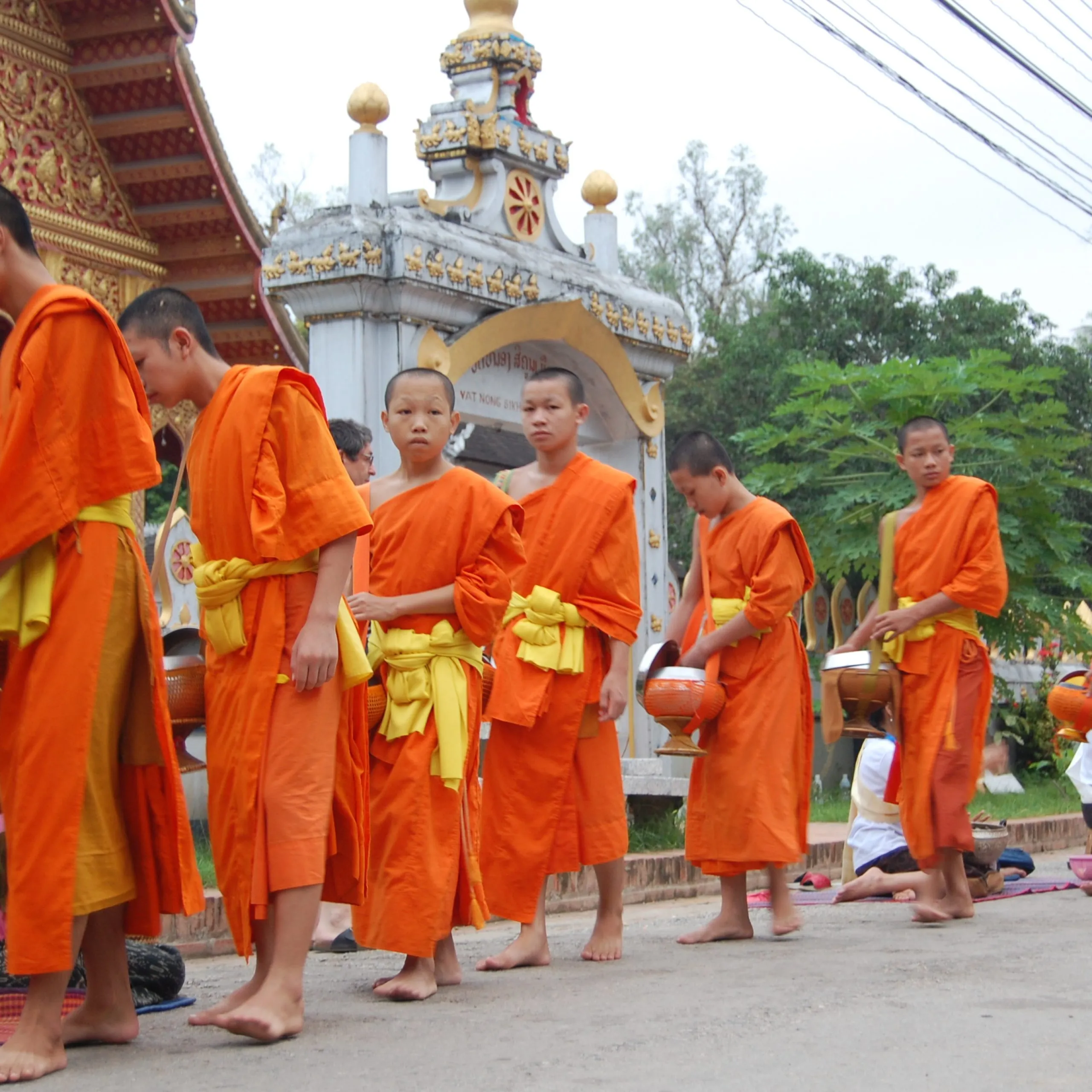 Luang Prabang Buddhist monks collecting alms on street Laos 2.jpg