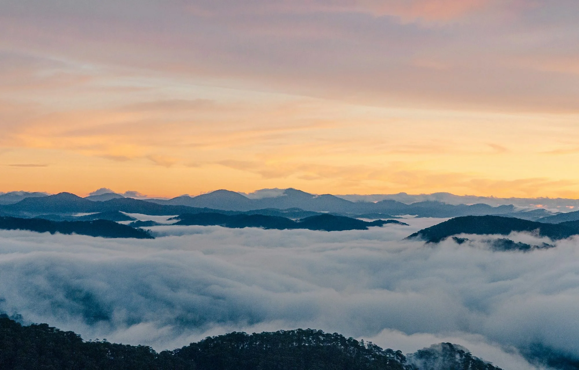 a view of a mountain range covered in clouds