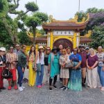 Ospiti di Metta Voyage con la loro guida davanti a una pagoda in Vietnam
