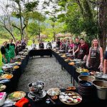 Un grande gruppo di viaggiatori Metta Voyage a un pranzo all'aperto in Vietnam