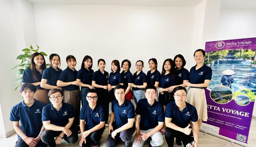 Tập thể nhân viên Metta Voyage mặc áo đồng phục xanh