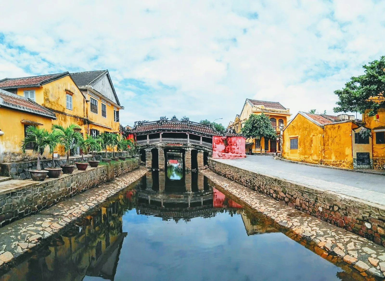 a river running through a city next to a yellow building