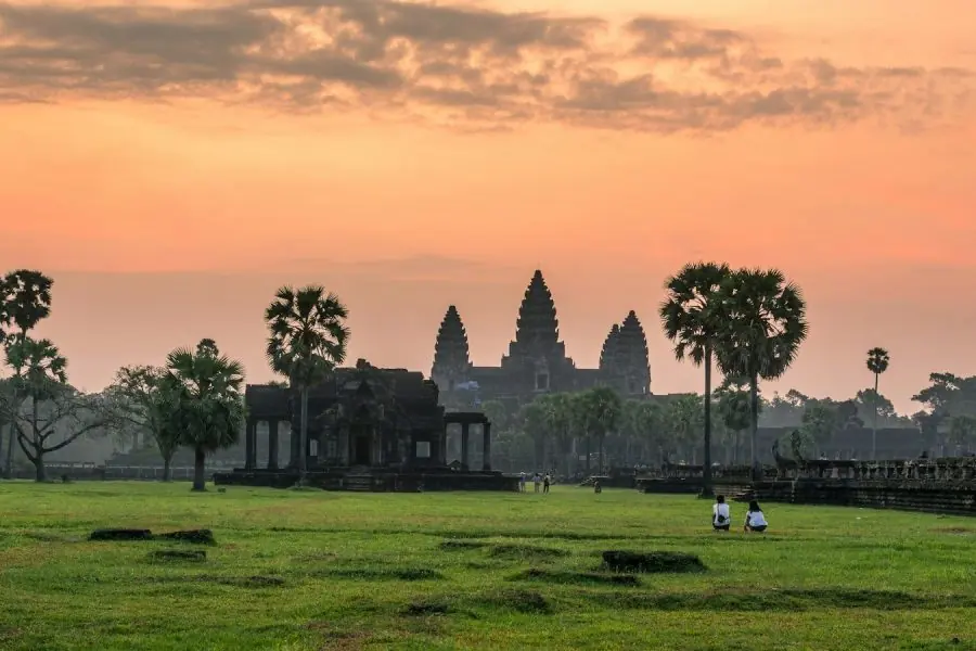 A group of people walking across a lush green field