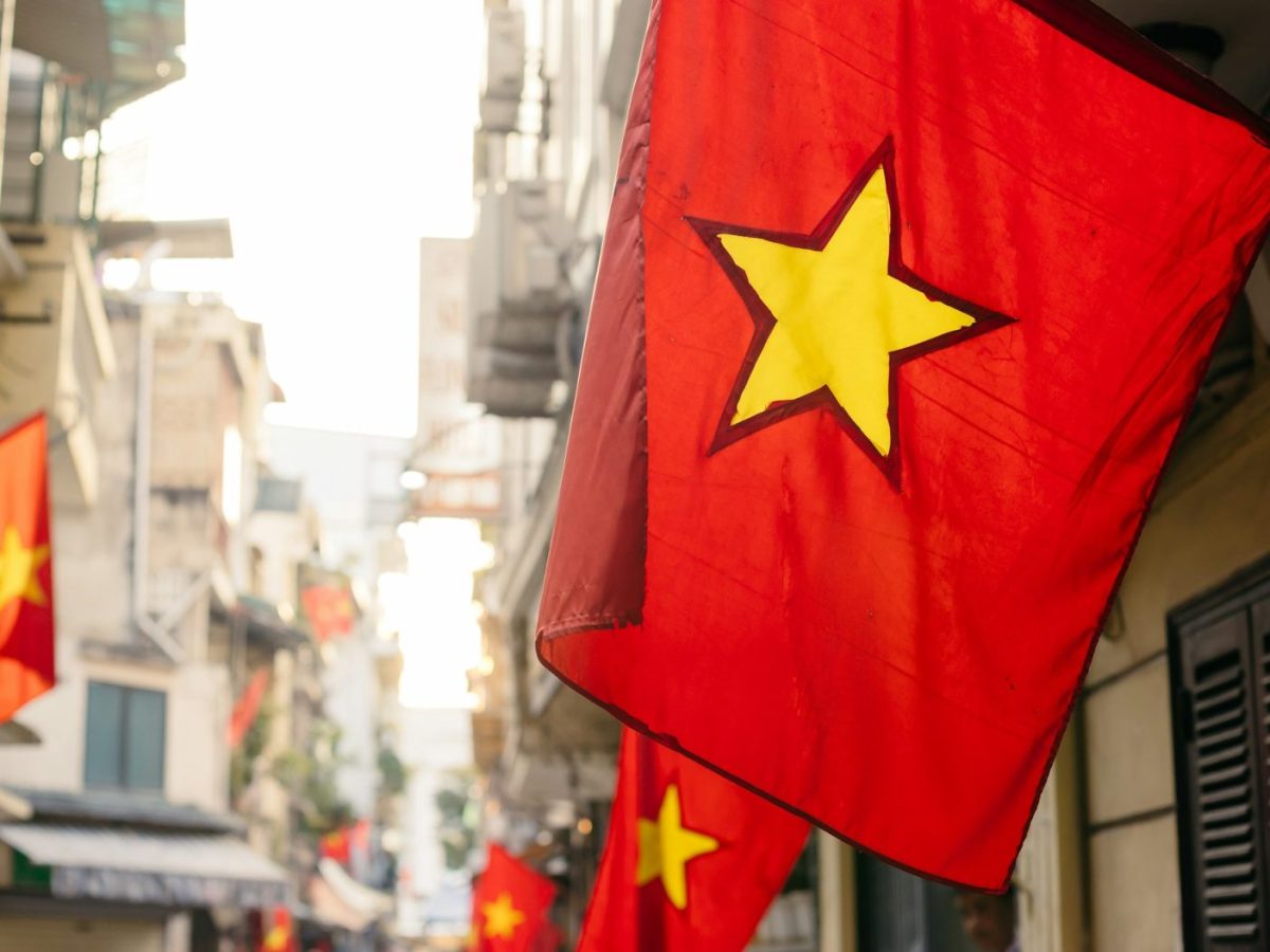 a red and yellow flag hanging from the side of a building