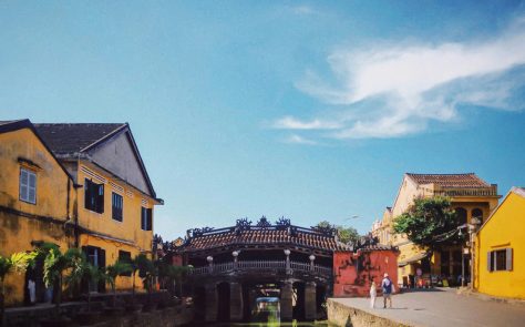 a bridge over a river between buildings