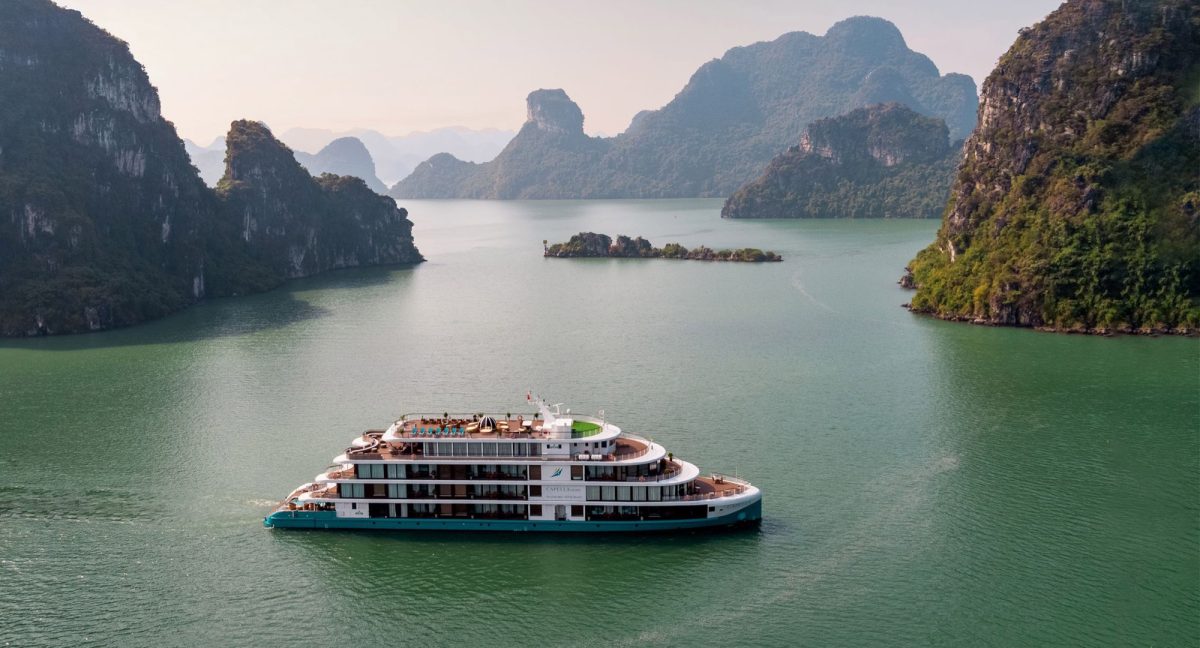 Capella Cruise, a white four-deck ship with rooftop pool, among the islands of Lan Ha Bay
