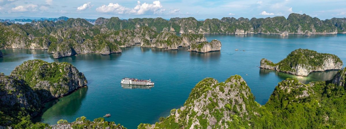 Aerial view of Indochine Grand cruise ship among the green islands of Lan Ha Bay