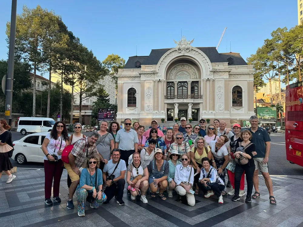 Un gruppo di viaggiatori davanti al Teatro dell’Opera di Saigon